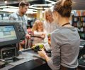 Beautiful family standing at the cash counter buying groceries at the supermarket